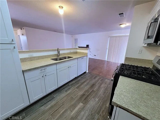 a kitchen with sink stove and cabinets