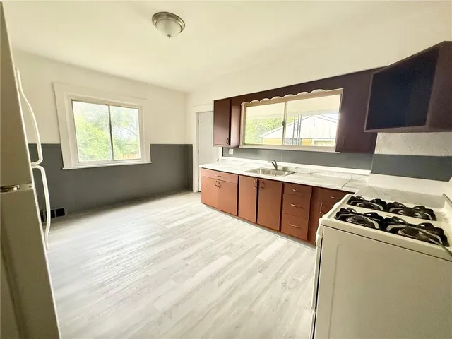 a kitchen with stainless steel appliances granite countertop a stove a sink and a refrigerator