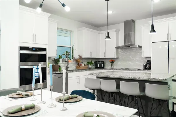 a kitchen with stainless steel appliances granite countertop a sink a stove and a microwave