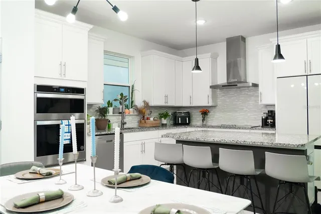 a kitchen with stainless steel appliances granite countertop a sink a stove and a microwave