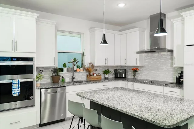 a kitchen with granite countertop a sink stainless steel appliances and cabinets