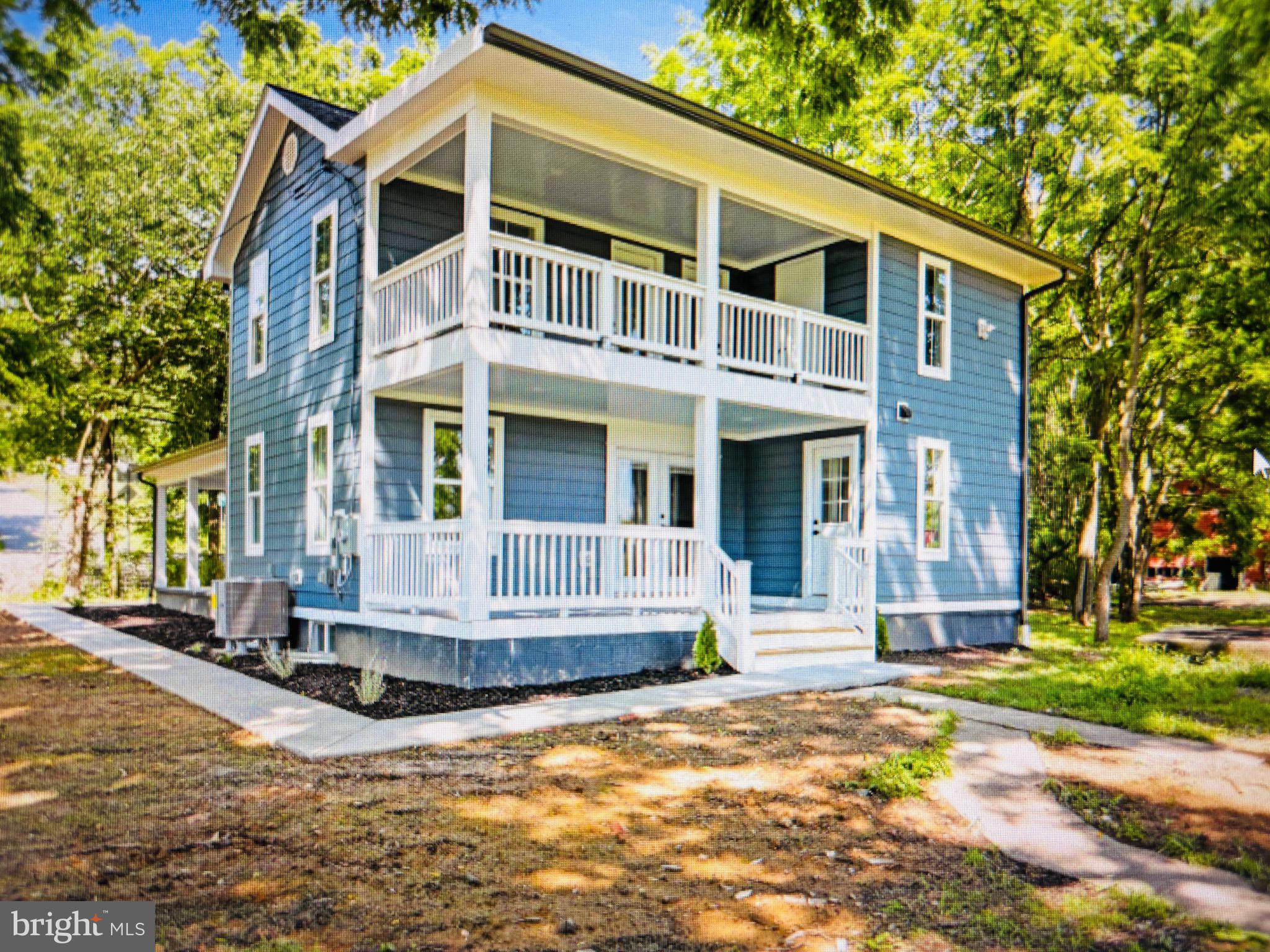 a view of a brick house with many windows plants and large tree