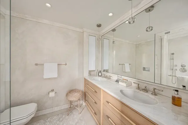 a bathroom with a double vanity sink toilet mirror and shower