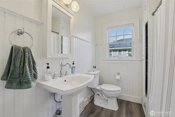 a bathroom with a sink a toilet and a mirror