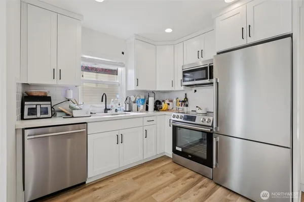 a kitchen with stainless steel appliances a refrigerator sink and microwave