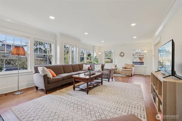 a living room with furniture a rug a flat screen tv and a window
