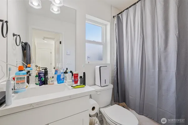 a bathroom with a sink vanity mirror and toilet
