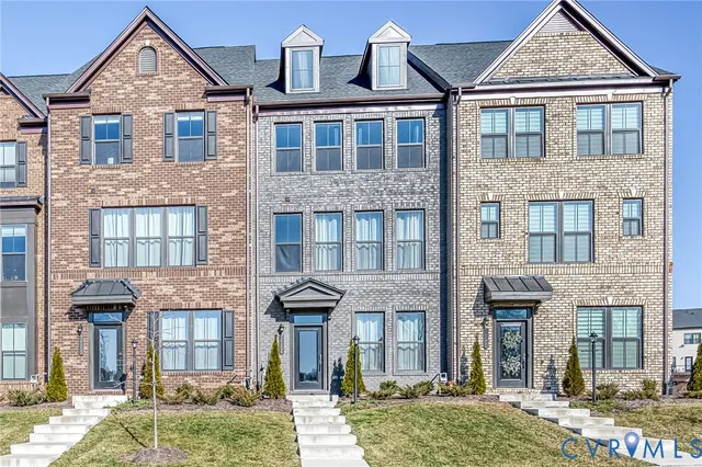 a front view of a residential apartment building with a yard