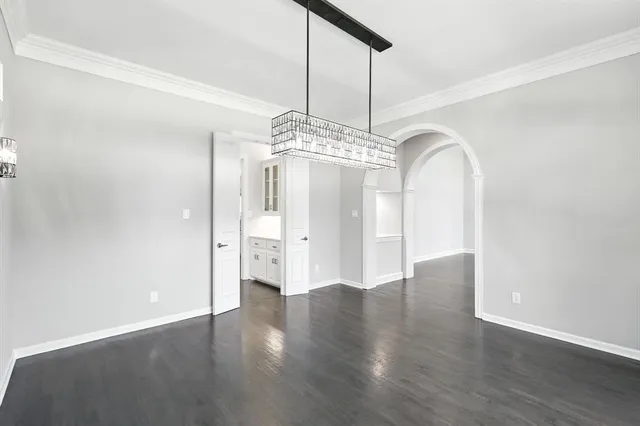 a view of a big room with wooden floor chandelier and a window