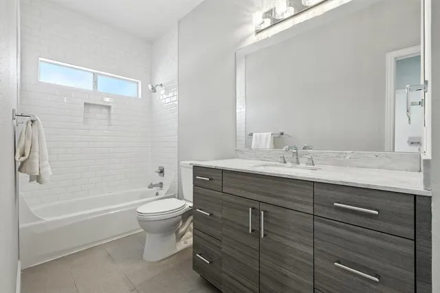 an empty room with chandelier fan and windows