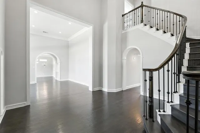 a view of a hallway with wooden floor and staircase
