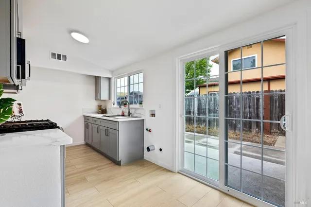 a living room with stainless steel appliances kitchen island furniture and a large window