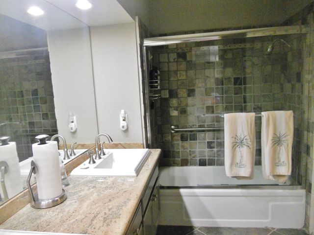 a bathroom with a granite countertop sink and a mirror
