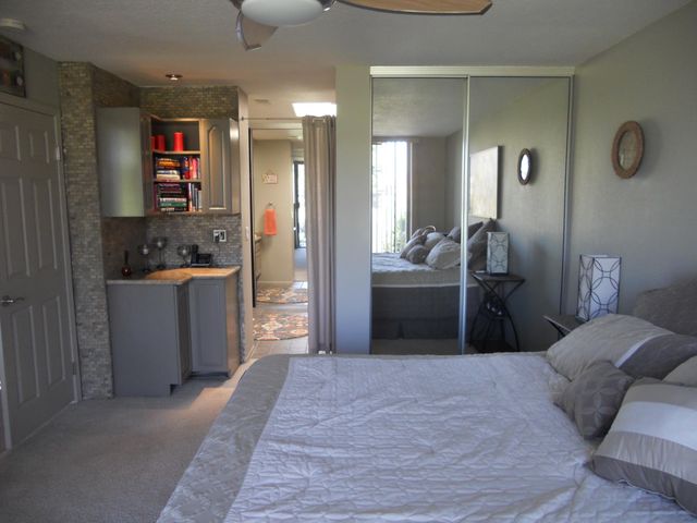 a bedroom with a bed and a view of kitchen