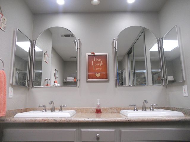 a bathroom with a double vanity sink and two mirror