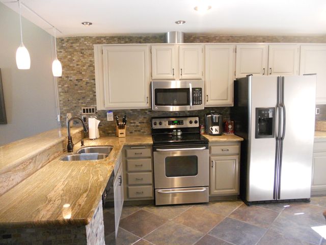 a kitchen with kitchen island a stove a sink and a refrigerator