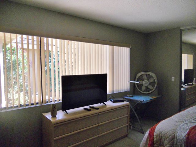a bedroom with bed and a flat screen tv