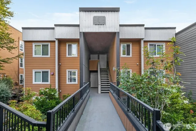 a view of a brick house with wooden fence and windows