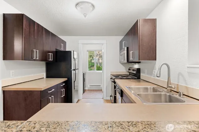 a kitchen with a refrigerator sink and wooden cabinets