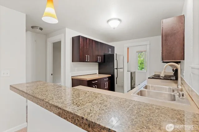 a kitchen with stainless steel appliances granite countertop a sink stove and refrigerator