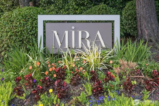 a sign that is sitting in front of flowers