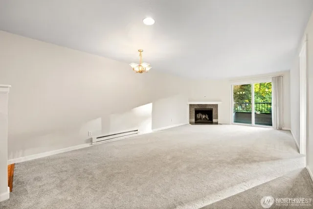 an empty room with windows and fireplace