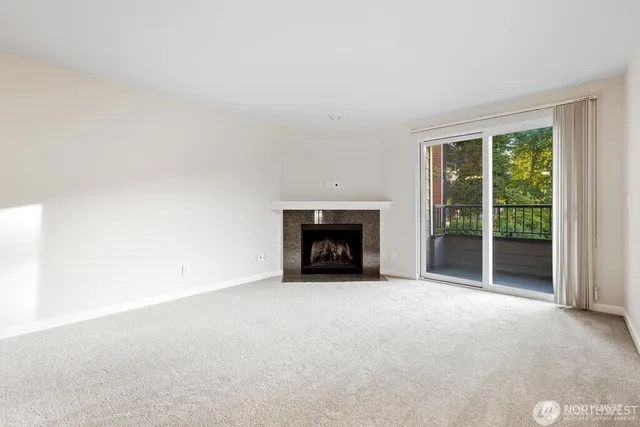 a view of an empty room with a fireplace and a window