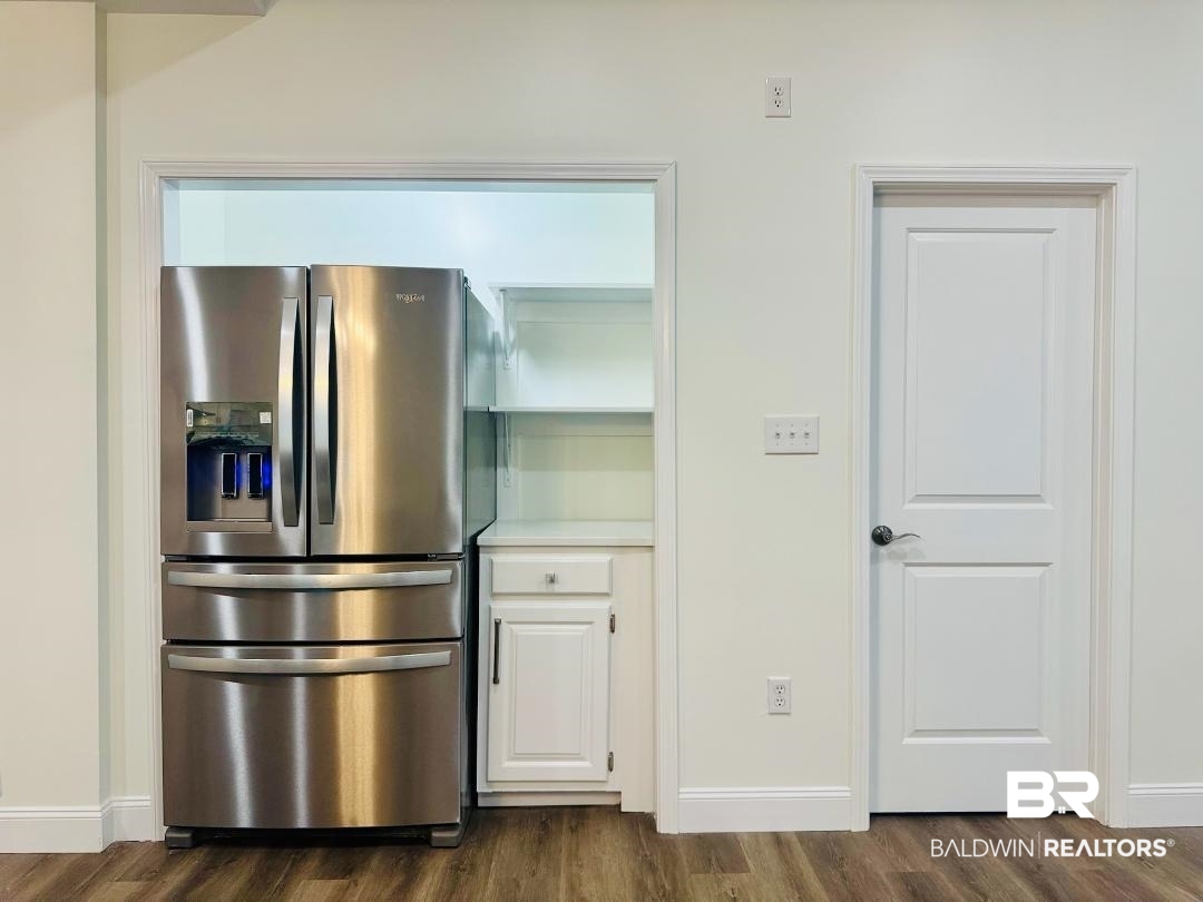 2663 Demetropolis Road Mobile, AL 36693 - Photo 13 of 26 Kitchen featuring stainless steel fridge with ice dispenser, dark wood-type flooring, white cabinetry, and light countertops