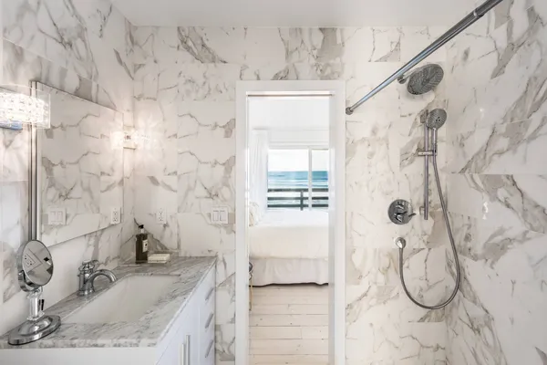 a bathroom with a granite countertop sink a toilet and shower