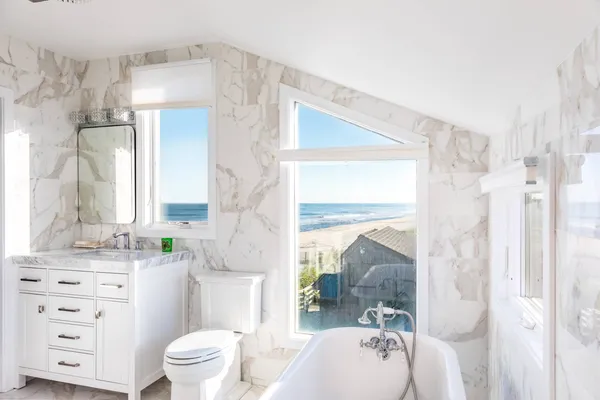 a bathroom with a sink a toilet a mirror a vanity and shower