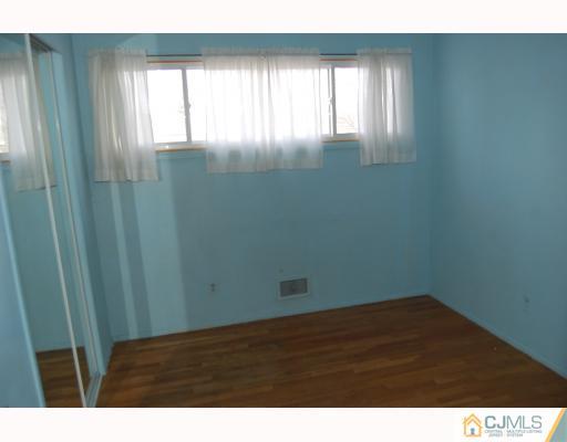 91 Princeton Road Old Bridge, NJ 08859 - Photo 9 of 9 a view of an empty room with wooden floor and a window