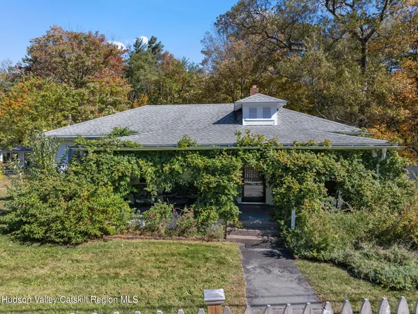 a view of a house with a yard and a large tree