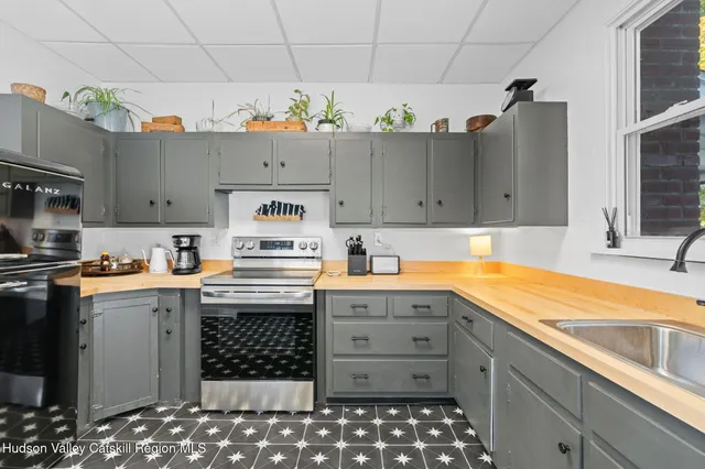 a kitchen with granite countertop a sink stainless steel appliances and cabinets