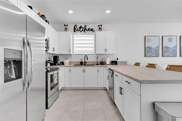 a kitchen with granite countertop a sink stainless steel appliances and cabinets