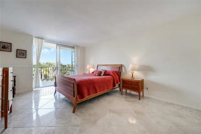 a spacious bedroom with a bed and wooden floor