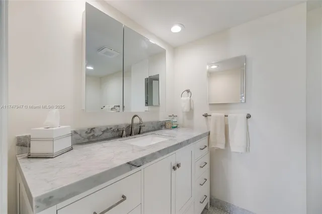 a bathroom with a granite countertop sink and a mirror
