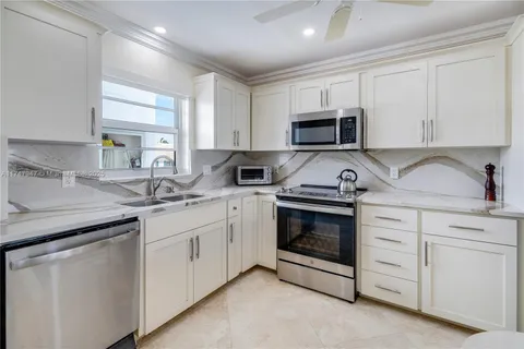 a kitchen with white cabinets stainless steel appliances and sink