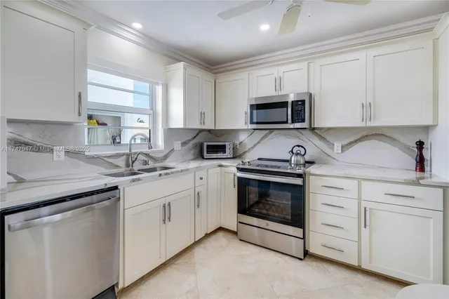 a kitchen with white cabinets stainless steel appliances and sink