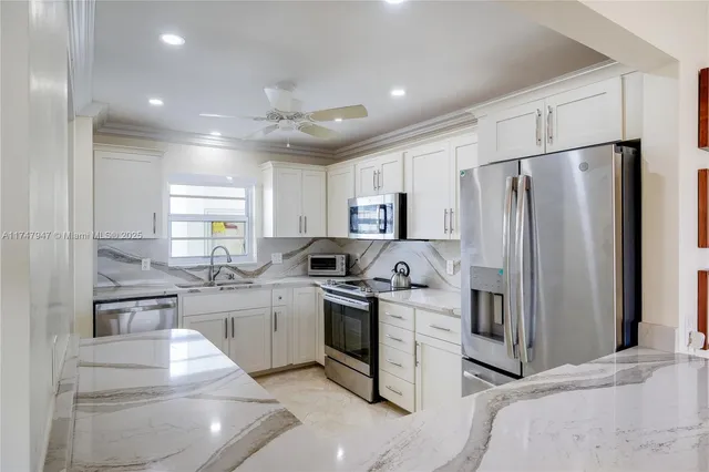 a kitchen with white cabinets and stainless steel appliances