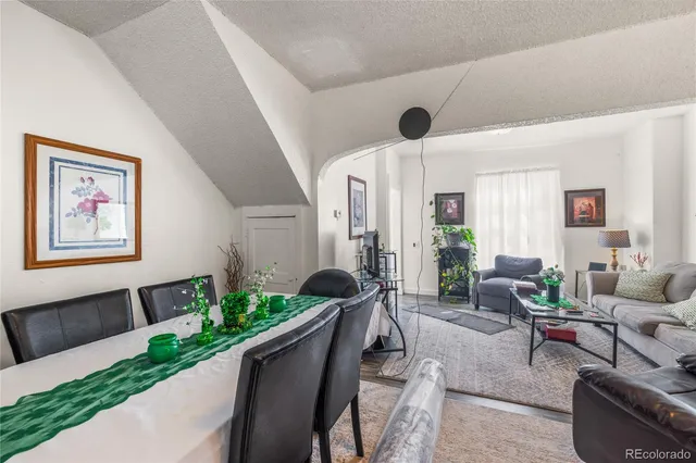 a living room with furniture potted plant and a large window