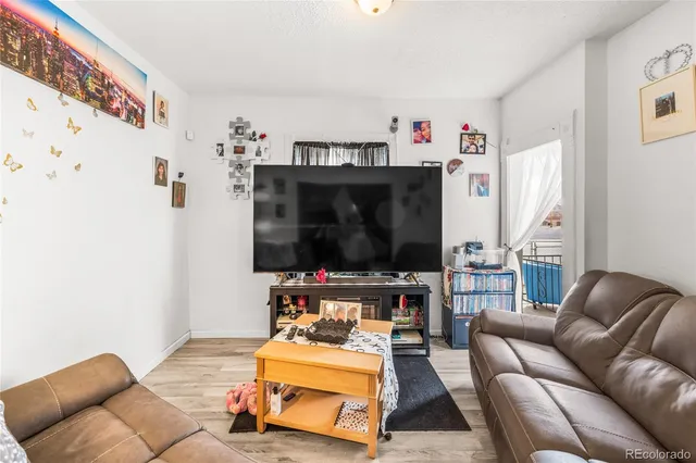 a living room with furniture a flat screen tv and a window