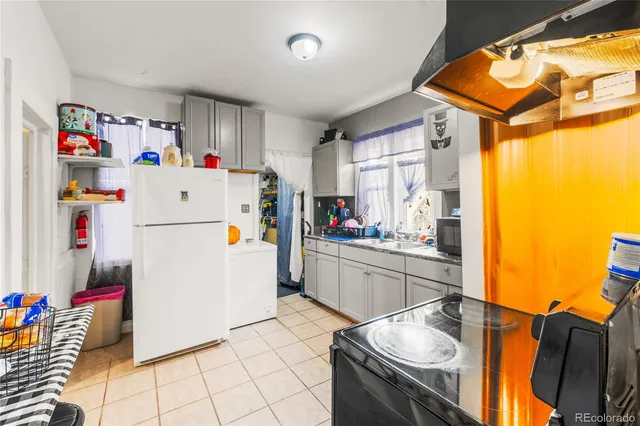 a kitchen with a refrigerator and a stove top oven