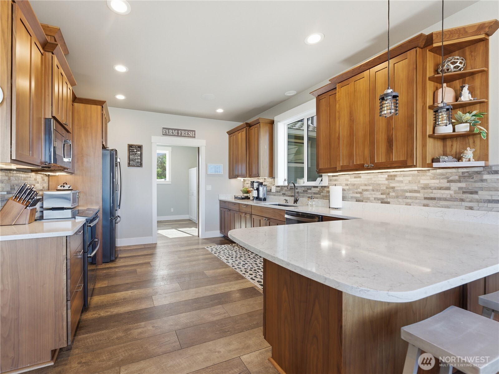 2128 McEldowney Road Malaga, WA 98828 - Photo 12 of 39 a large kitchen with kitchen island a large counter top space a sink stainless steel appliances and cabinets