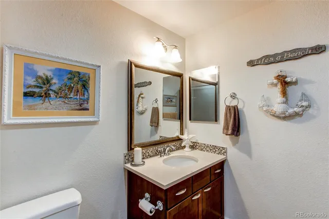 a bathroom with a sink a toilet a mirror and shower