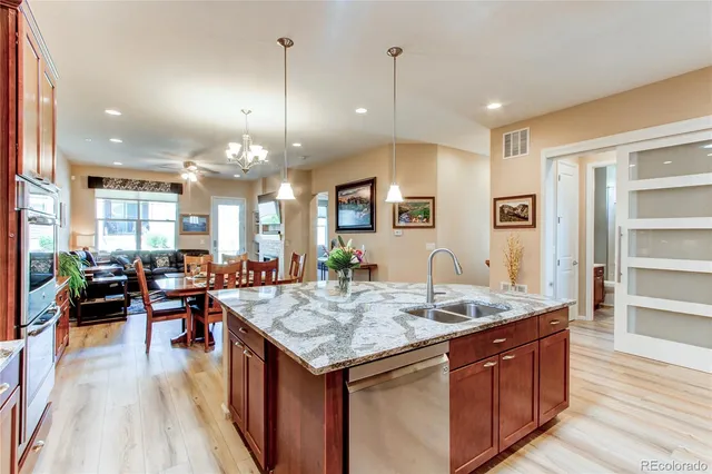 a kitchen with stainless steel appliances granite countertop wooden floor and refrigerator