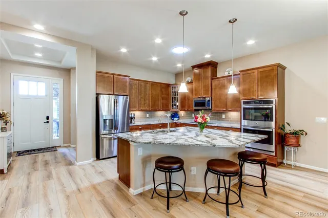 a view of a dining room with furniture a kitchen and chandelier