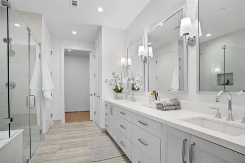 a bathroom with a double vanity sink mirror and shower