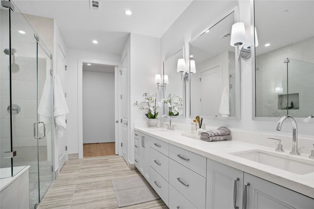 a bathroom with a double vanity sink mirror and shower