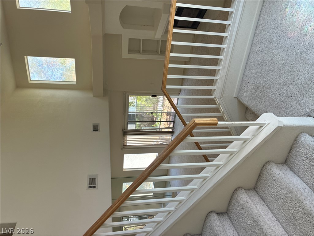 5272 Island Chain Road Las Vegas, NV 89118 - Photo 39 of 39 A grand staircase with pristine carpet leads to sun-filled upper levels with high ceilings and skylights.
