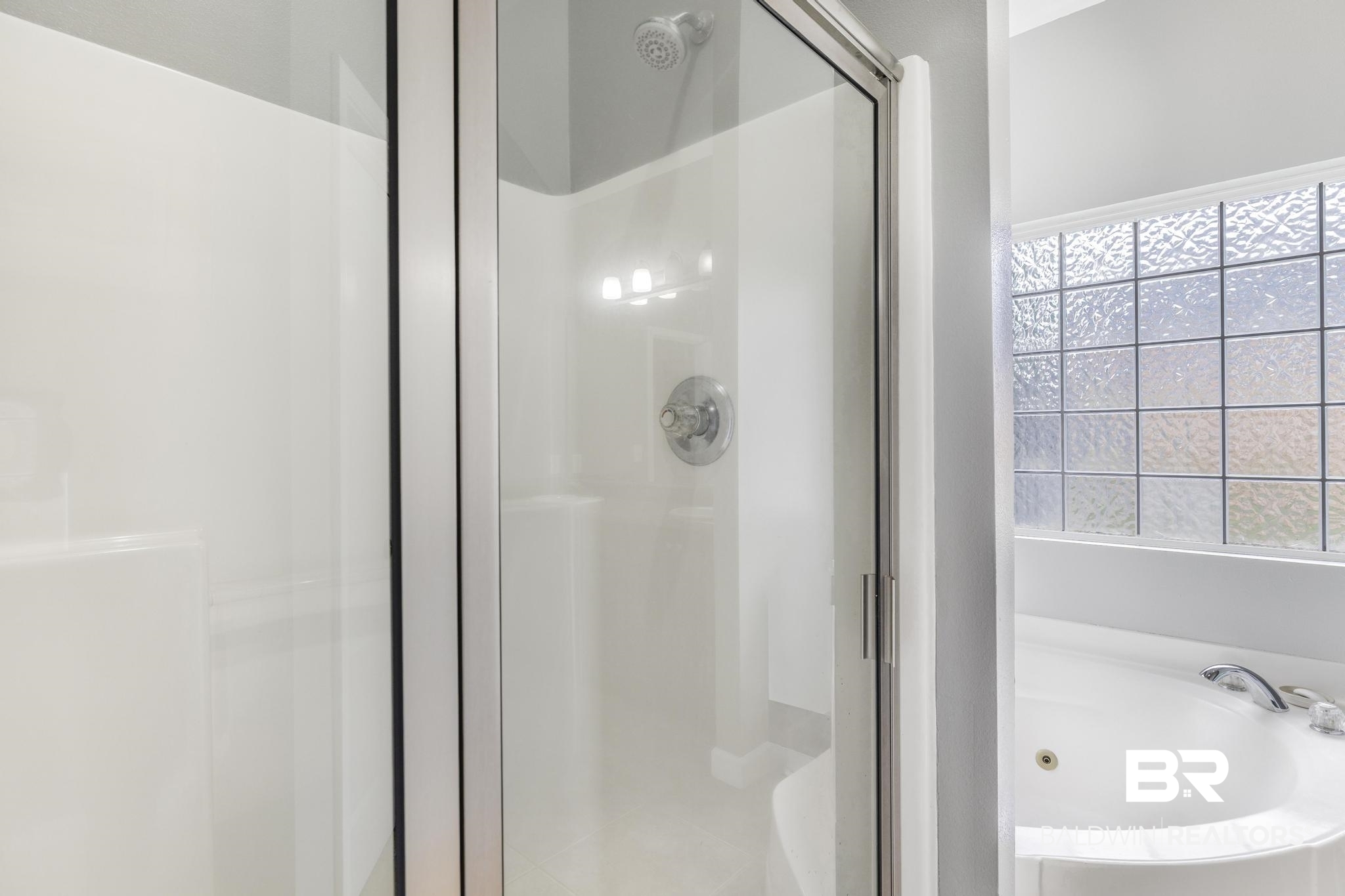 35814 Delvan Lane Bay Minette, AL 36507 - Photo 36 of 53 White shower enclosure with clear glass door, chrome fixtures, and integrated shelving
